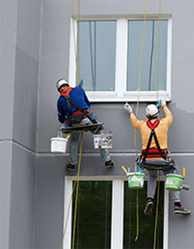 Pintores de vertilan pintando fachada en vertical